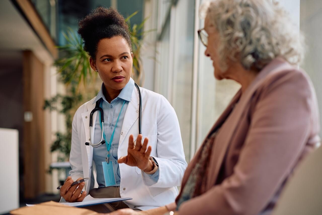 African American doctor talking to a senior woman after medical examination at the hospital.